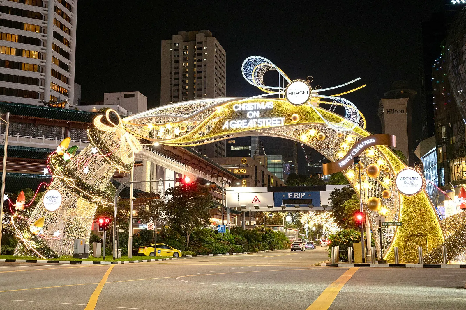 Lit Christmas archway over Orchard Road at night