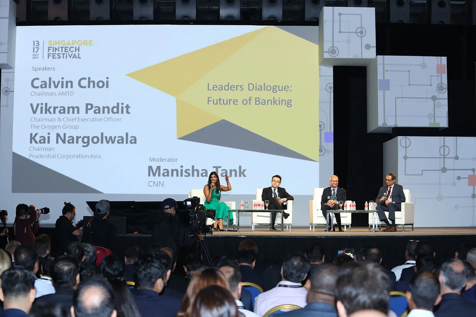 Panel discussion on stage in front of an audience at an earlier Singapore FinTech Festival